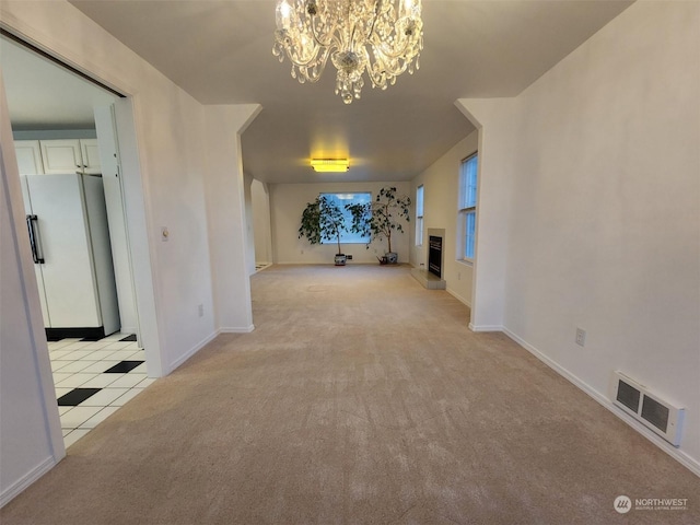 151 Rilla Ln, Sequim, WA 98382 - unfurnished living room with a chandelier, light colored carpet, baseboards, light tile patterned floors, and a fireplace