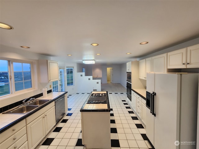 kitchen with tile countertops, white fridge with ice dispenser, stainless steel dishwasher, and sink