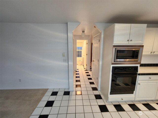 151 Rilla Ln, Sequim, WA 98382 - kitchen with oven, stainless steel microwave, tile countertops, white cabinets, and light tile patterned floors
