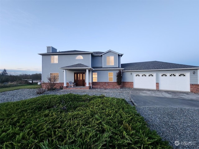 151 Rilla Ln, Sequim, WA 98382 - traditional-style home featuring brick siding, an attached garage, concrete driveway, and a chimney