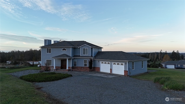 view of property featuring a garage and a lawn