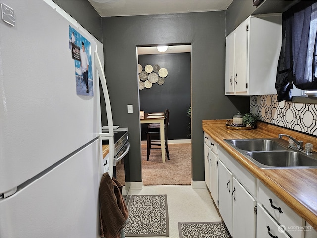 kitchen with white fridge, sink, and white cabinets