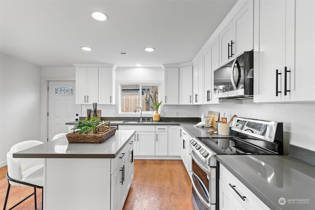 kitchen featuring light hardwood / wood-style floors, stainless steel appliances, sink, and white cabinets