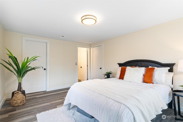 bedroom with dark hardwood / wood-style floors