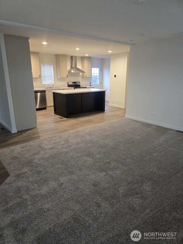1011 N 34th Ave Unit 59, Yakima, WA 98902 - kitchen featuring appliances with stainless steel finishes, wall chimney exhaust hood, open floor plan, baseboards, and recessed lighting