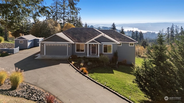 ranch-style house featuring a garage, a front yard, and a mountain view