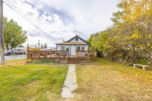 bungalow with a front lawn and a deck