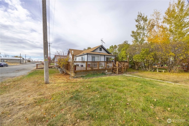 back of property featuring a wooden deck and a yard