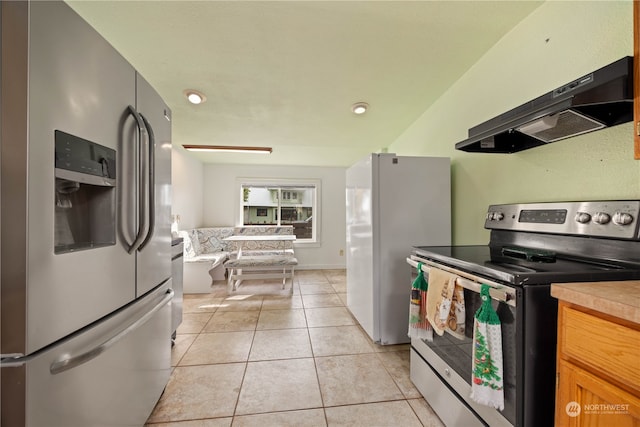 kitchen with appliances with stainless steel finishes, range hood, and light tile patterned flooring