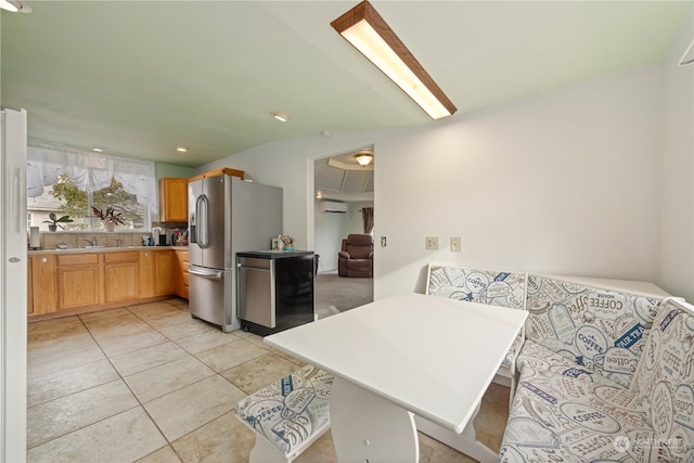 kitchen featuring a kitchen bar, kitchen peninsula, stainless steel fridge, a wall mounted AC, and light tile patterned floors