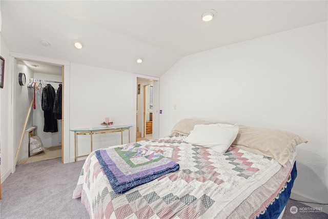 carpeted bedroom with lofted ceiling and a closet