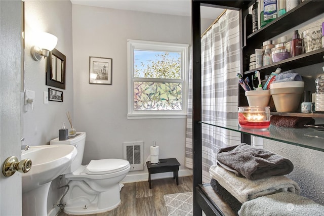 bathroom featuring wood-type flooring, toilet, and sink