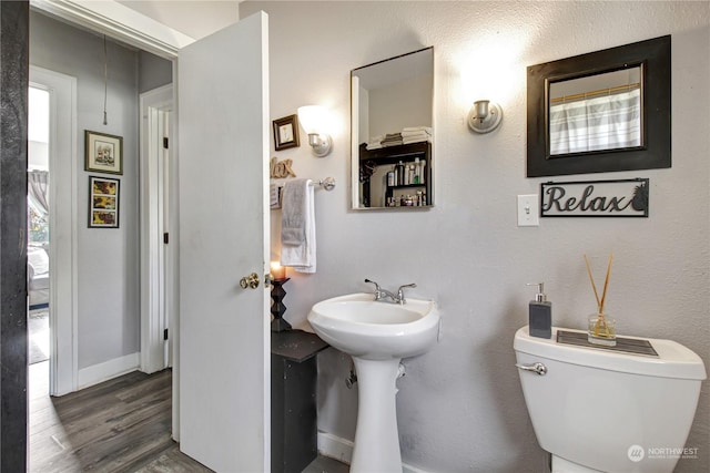 bathroom with toilet and hardwood / wood-style flooring