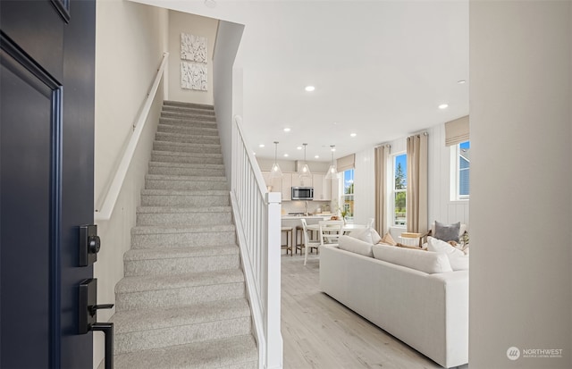 stairs featuring recessed lighting and wood finished floors