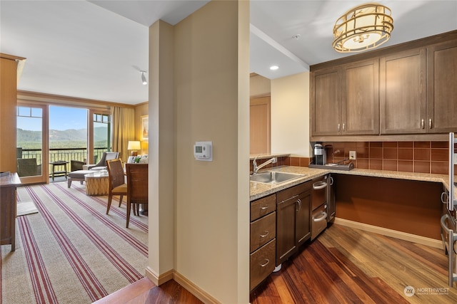 kitchen featuring a mountain view, dark wood-type flooring, sink, and light stone counters