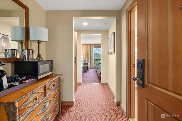 hall featuring dark colored carpet