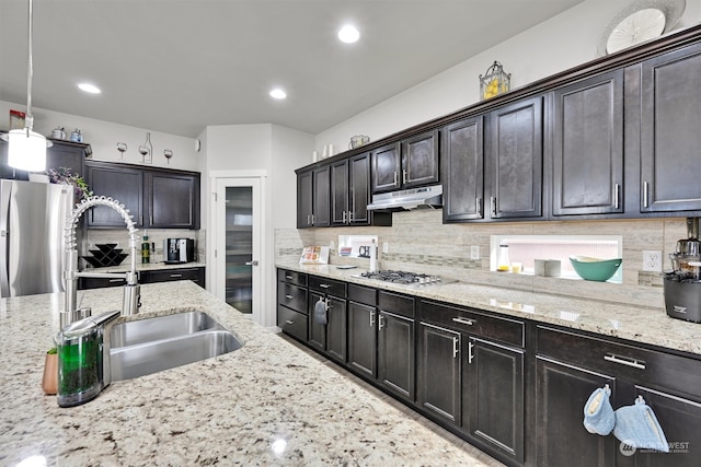 kitchen featuring decorative backsplash, sink, dark brown cabinets, and pendant lighting