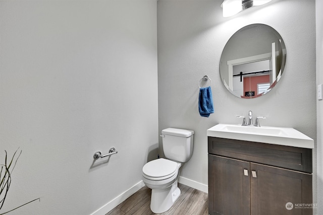 bathroom with vanity, toilet, and hardwood / wood-style flooring