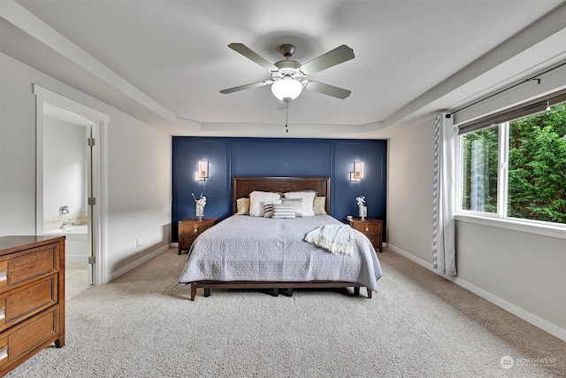 carpeted bedroom with ensuite bathroom and ceiling fan