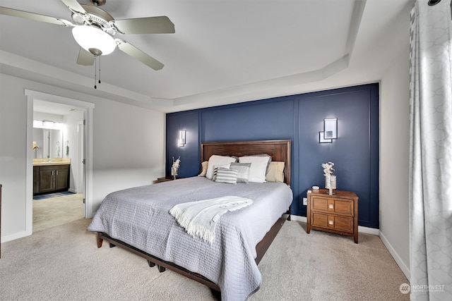 carpeted bedroom with ensuite bath and ceiling fan