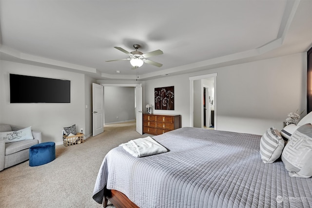 bedroom featuring ceiling fan, light carpet, and a raised ceiling