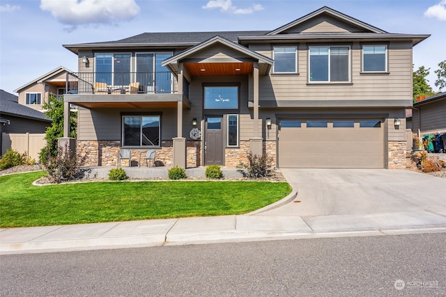 view of front facade featuring a balcony, a garage, and a front lawn