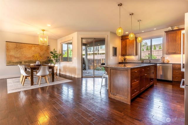 kitchen with dishwasher, hanging light fixtures, dark wood-type flooring, and a center island