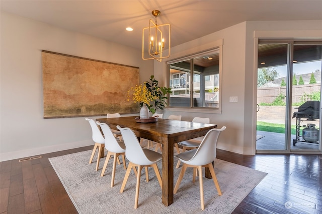 dining space featuring dark hardwood / wood-style flooring and a notable chandelier