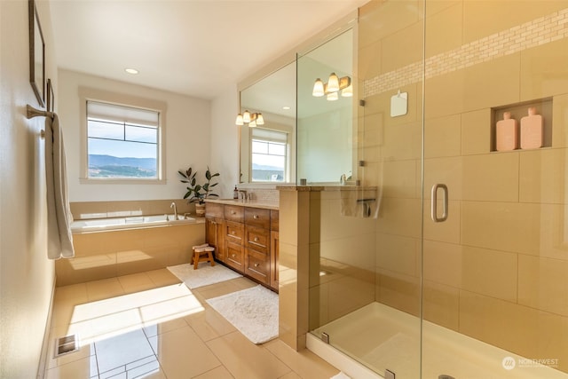 bathroom featuring vanity, a chandelier, tile patterned floors, and plus walk in shower