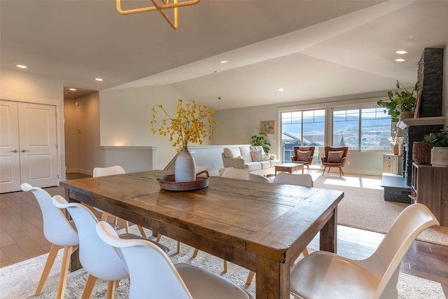 dining area featuring hardwood / wood-style flooring and vaulted ceiling