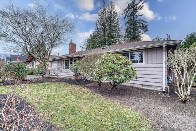 view of front of property featuring a chimney, a front yard, and board and batten siding