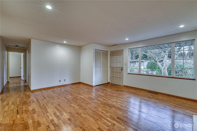 interior space with light wood-style floors, recessed lighting, visible vents, and baseboards