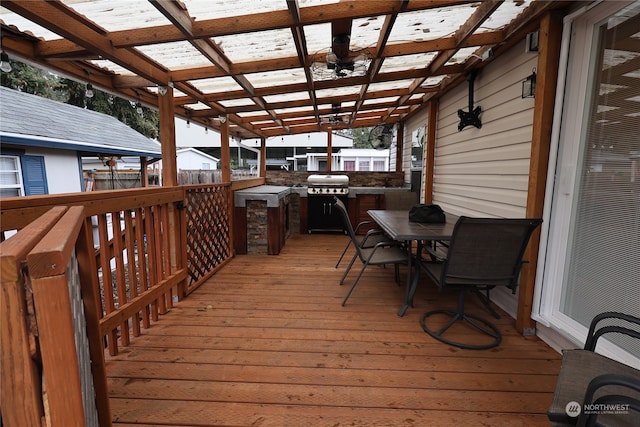 wooden terrace with area for grilling and a pergola