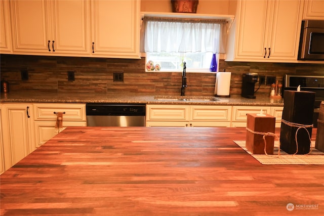 kitchen with backsplash, appliances with stainless steel finishes, sink, and white cabinets