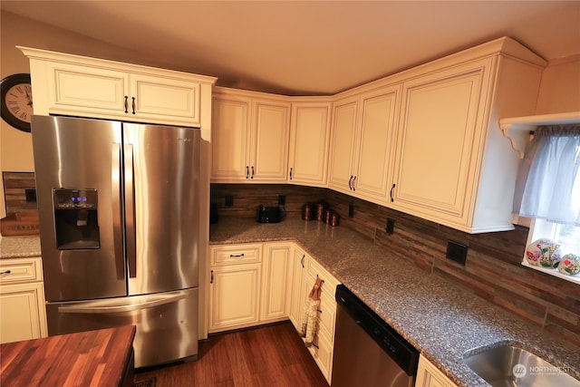 kitchen featuring dark hardwood / wood-style flooring, decorative backsplash, butcher block countertops, white cabinetry, and appliances with stainless steel finishes