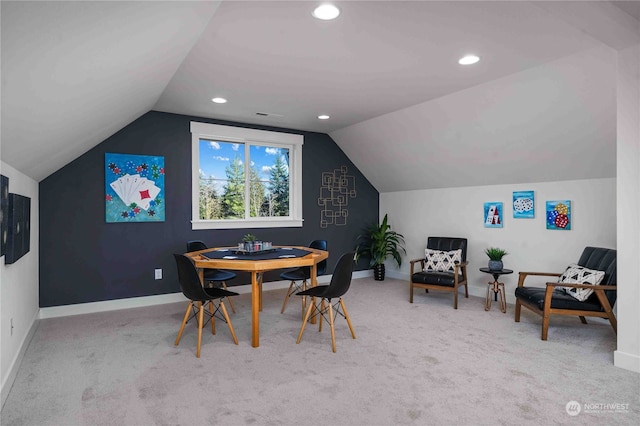 carpeted dining room featuring lofted ceiling