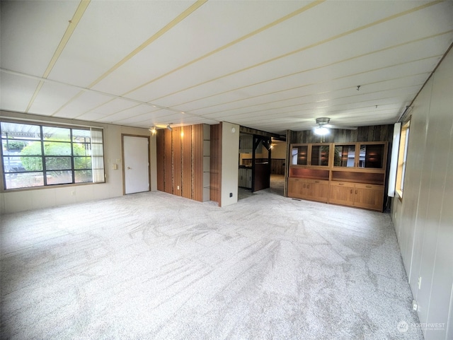 unfurnished living room with carpet and ceiling fan