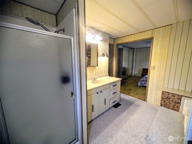 bathroom with wood walls, vanity, and a shower with door