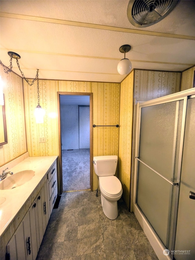 bathroom featuring toilet, an enclosed shower, and vanity