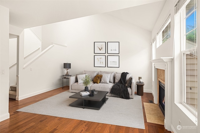 living room featuring hardwood / wood-style flooring, lofted ceiling, and a fireplace