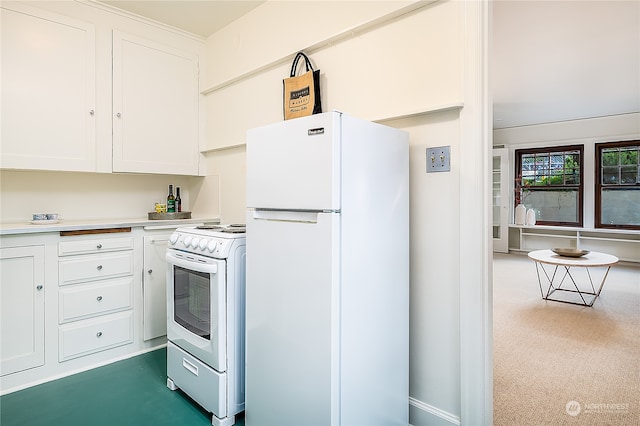 kitchen featuring dark colored carpet, white appliances, and white cabinetry