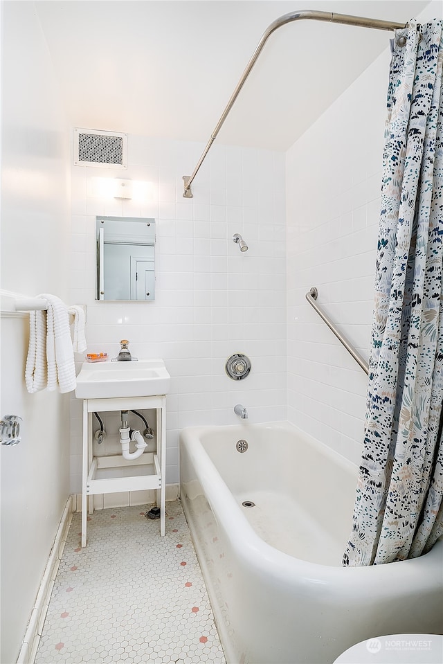 bathroom featuring shower / tub combo with curtain, tile patterned floors, and sink