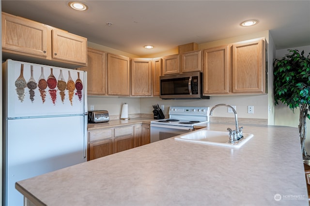 kitchen with white appliances, light brown cabinetry, and sink