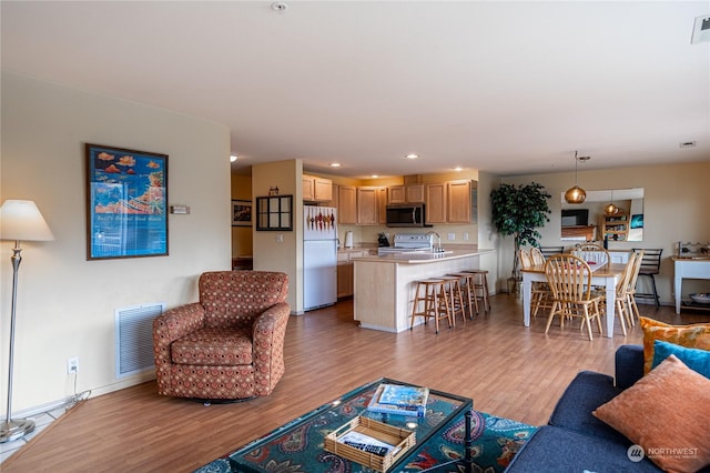 living room featuring wood finished floors, baseboards, and recessed lighting