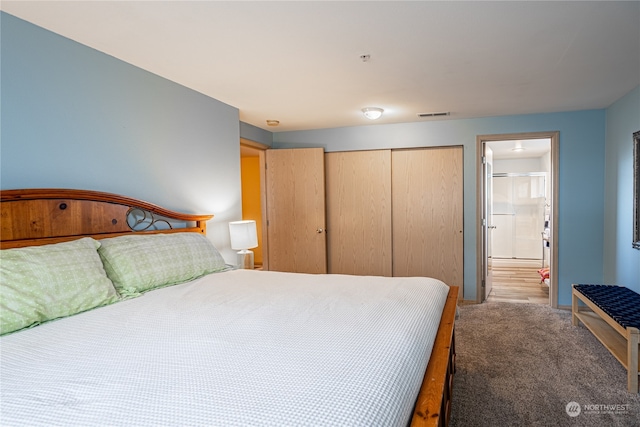 carpeted bedroom with a closet and ensuite bath