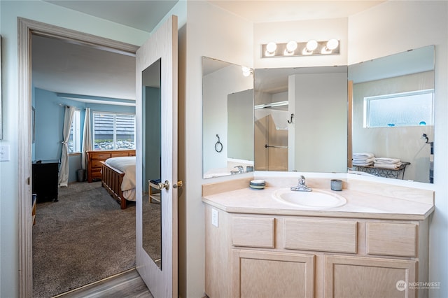 bathroom featuring vanity, a shower, and hardwood / wood-style floors