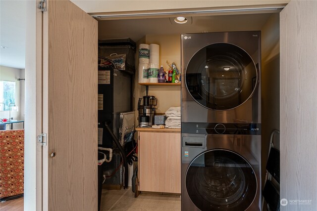 washroom featuring stacked washer / drying machine