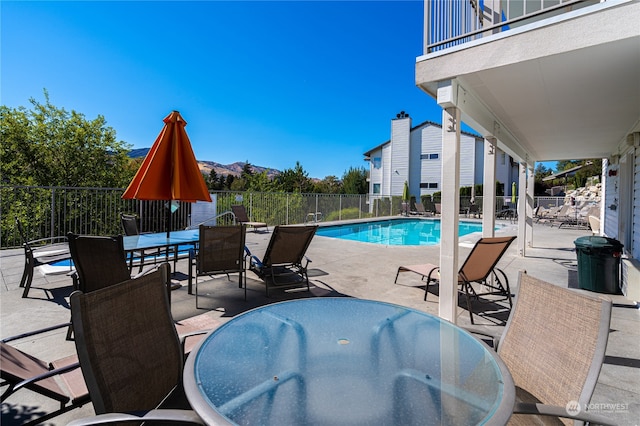 view of pool featuring a mountain view and a patio