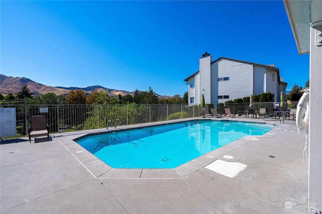 view of swimming pool with a mountain view and a patio area