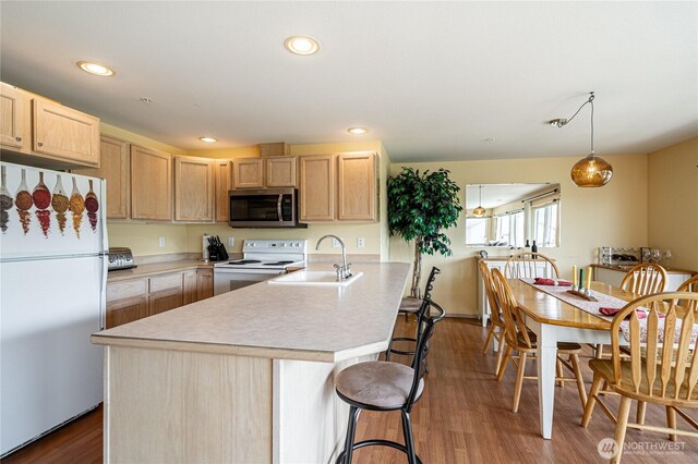 808 W Manson Rd Unit B204, Chelan, WA 98816 - kitchen with white appliances, a sink, light brown cabinets, a breakfast bar, and recessed lighting